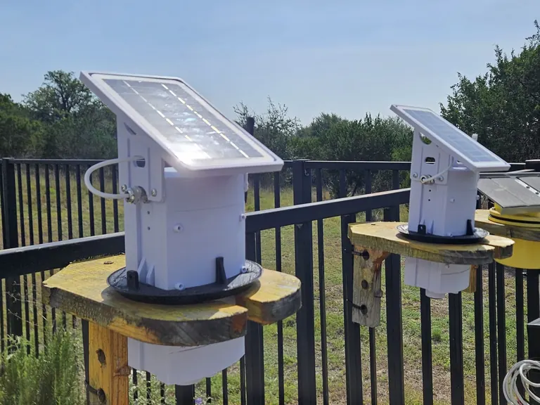 Close view of the Trivertix transmitter: a white waterproof housing with a tilted solar panel on top
